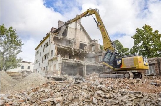Gebäudeabbruch Hamburg: Großer Kettenbagger mit Abbruchausleger beim maschinellen Rückbau eines mehrgeschossigen Gebäudes.