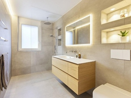 Badmodernisierung Hamburg modernes Badezimmer mit Waschtisch, beleuchtetem Spiegel, Dusche und stilvoller Ausstattung